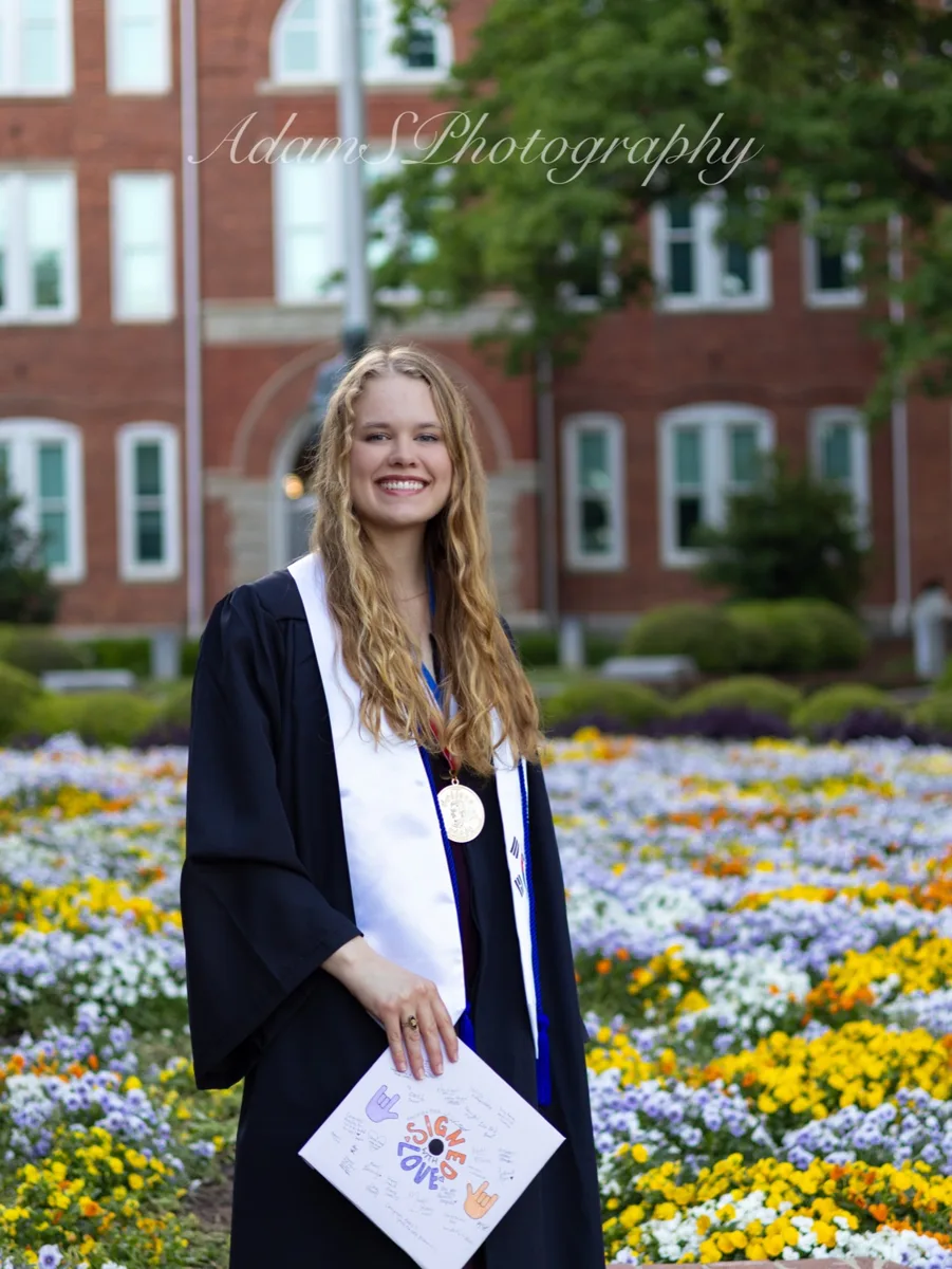 A graduation portrait among flowers on campus